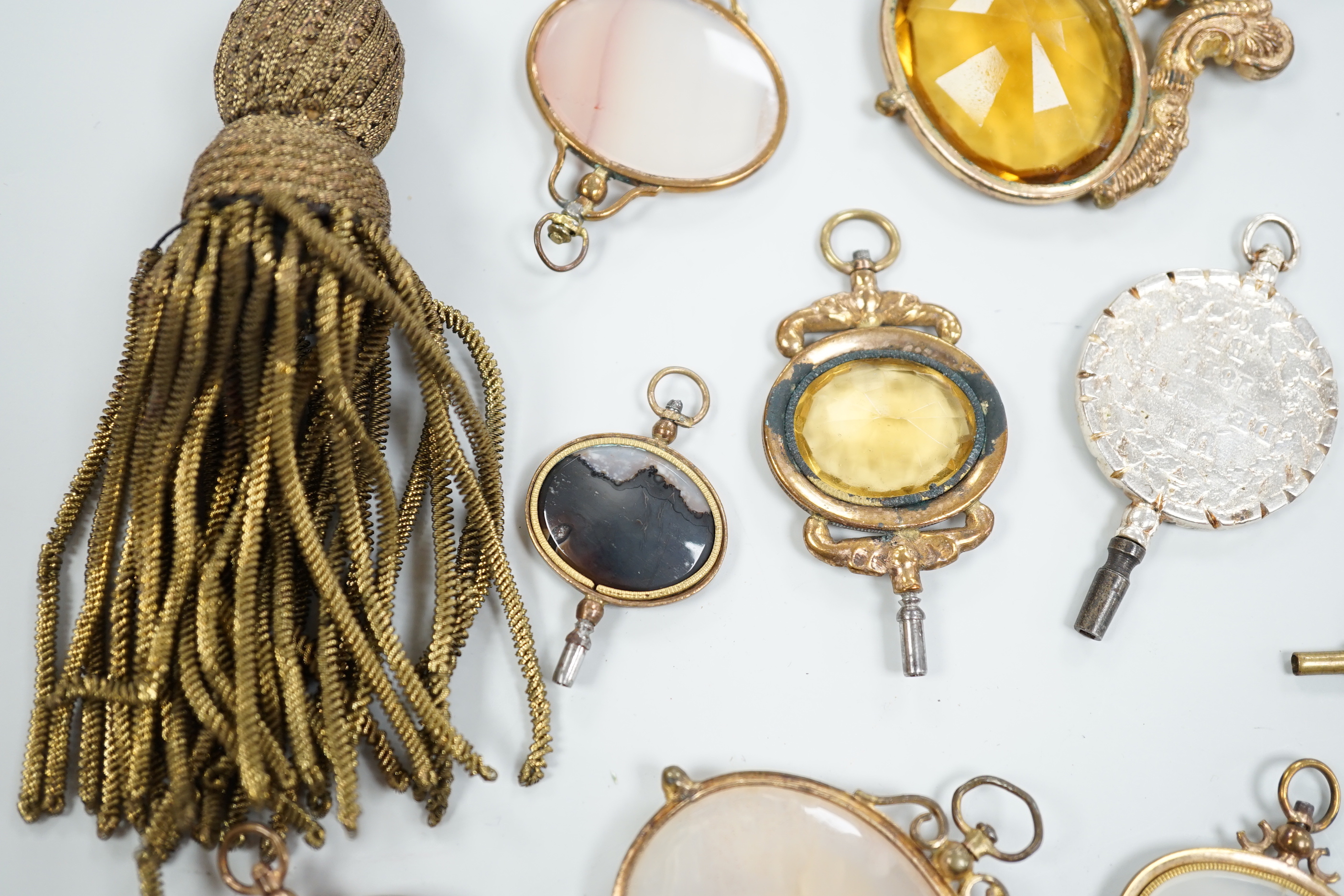 Ten assorted mainly 19th century base or yellow metal oval and gem set large watch keys, including agate and citrine paste and one set with French medallion, largest 69mm.